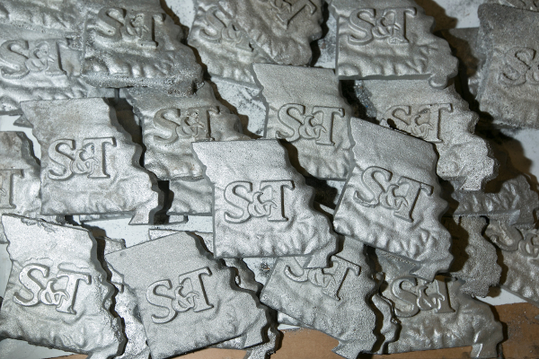 An image of multiple S&T marked Missouri shaped pieces of aluminum alloy